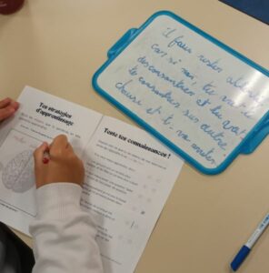 Un élève remplit son carnet au cours du projet Mission Cerveau. 