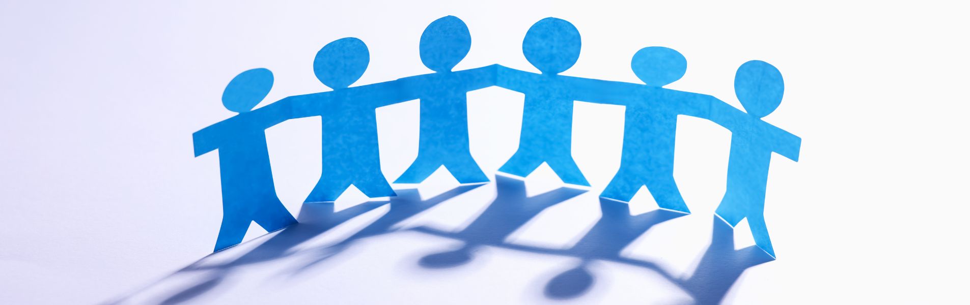 Des bonhommes en papier se tiennent la main.